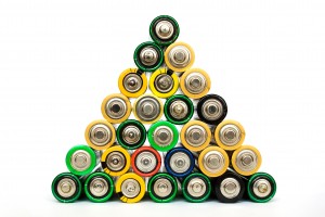 Deatil of many assorted AA batteries stacked in a pyramide isolated on a white background